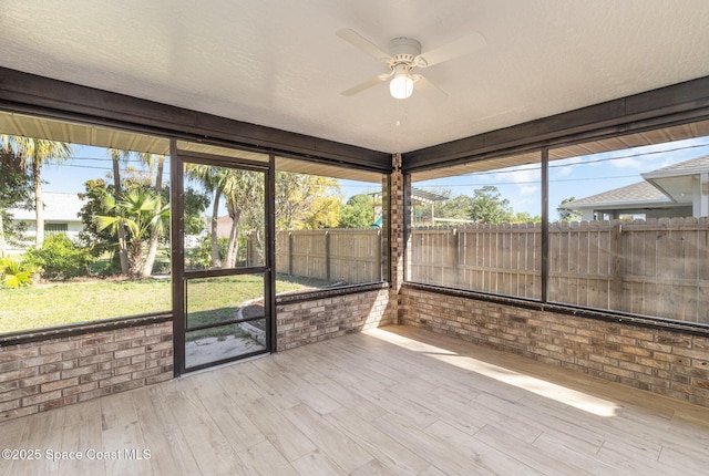 unfurnished sunroom featuring a ceiling fan