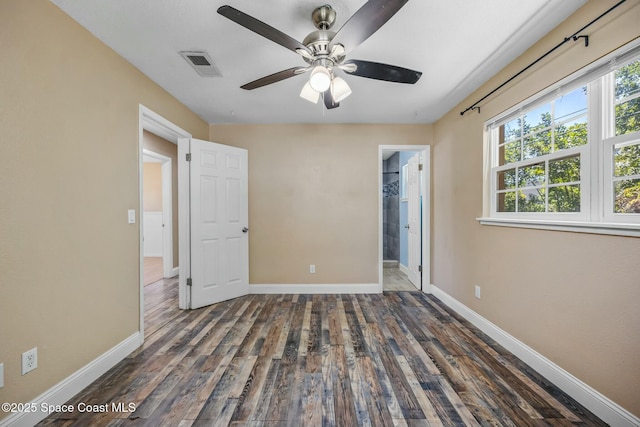 unfurnished bedroom with ceiling fan, wood finished floors, visible vents, and baseboards