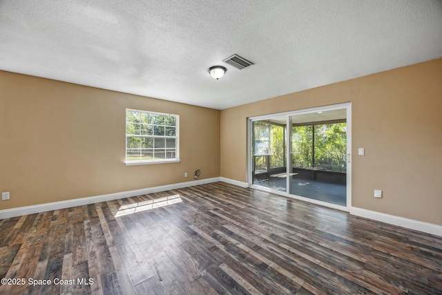 unfurnished room with dark wood-type flooring, plenty of natural light, baseboards, and visible vents