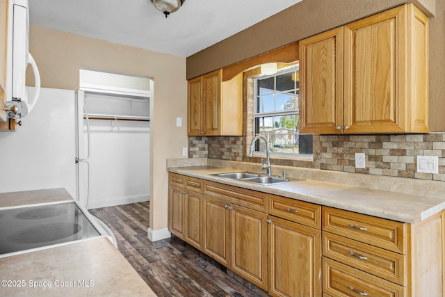 kitchen with white appliances, a sink, light countertops, dark wood-type flooring, and tasteful backsplash