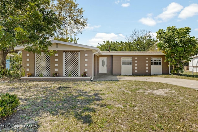 view of front of property featuring concrete block siding and a front yard