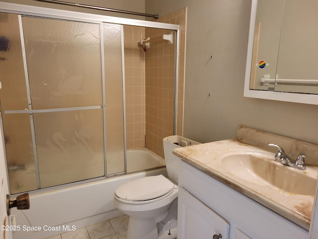 bathroom featuring tile patterned floors, enclosed tub / shower combo, toilet, and vanity