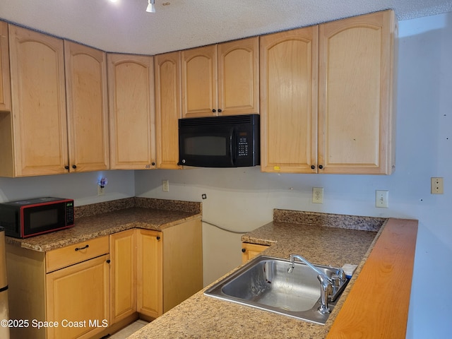 kitchen featuring light brown cabinets, a textured ceiling, black microwave, and a sink