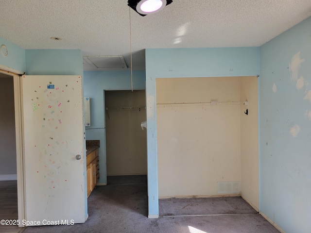 unfurnished bedroom featuring visible vents, a textured ceiling, and a closet