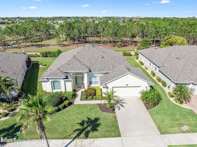 view of front facade with a front lawn, an attached garage, driveway, and stucco siding