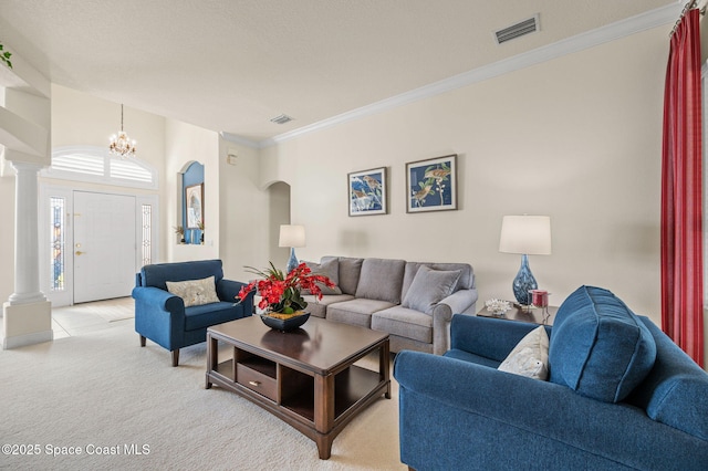 living area with visible vents, ornamental molding, and decorative columns