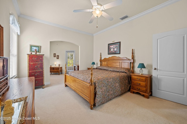 bedroom featuring a ceiling fan, visible vents, arched walkways, crown molding, and light colored carpet