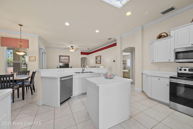 kitchen featuring visible vents, arched walkways, a sink, light countertops, and appliances with stainless steel finishes