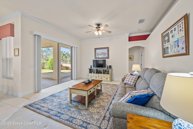 tiled living room with baseboards, visible vents, arched walkways, and ornamental molding