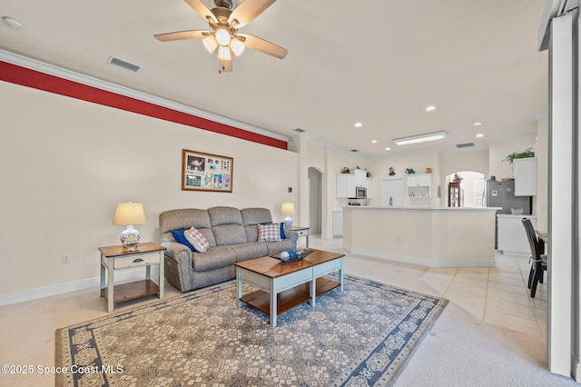 living room featuring a ceiling fan, visible vents, recessed lighting, arched walkways, and crown molding