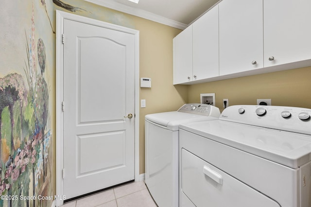 washroom featuring light tile patterned floors, cabinet space, crown molding, and washing machine and clothes dryer