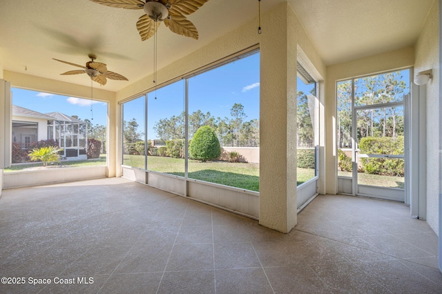 unfurnished sunroom with ceiling fan