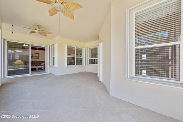 unfurnished sunroom with a ceiling fan