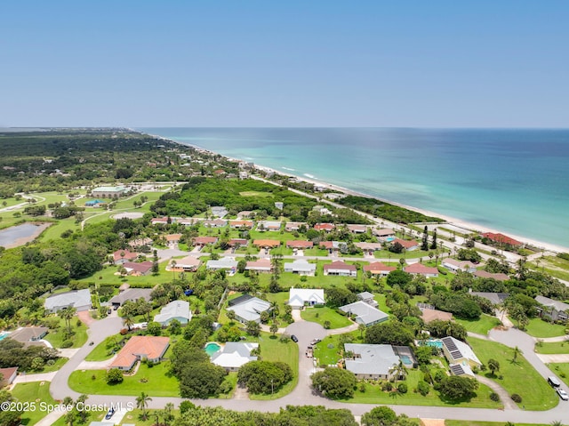 drone / aerial view with a residential view, a water view, and a view of the beach