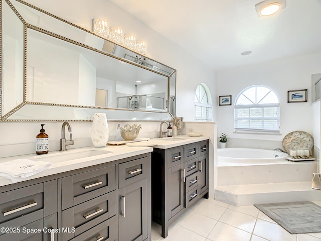 bathroom with a sink, a garden tub, double vanity, and tile patterned floors