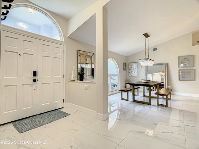 entryway with vaulted ceiling, visible vents, marble finish floor, and baseboards