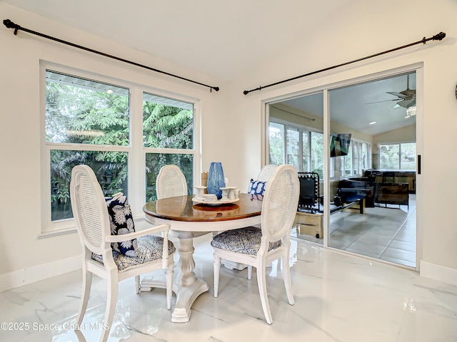 dining area featuring a healthy amount of sunlight, baseboards, and lofted ceiling