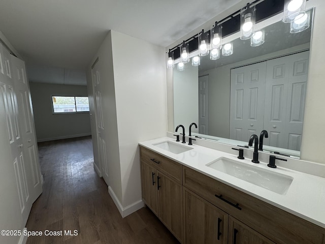 bathroom with wood finished floors, baseboards, and a sink