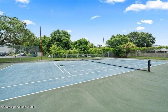 view of tennis court featuring fence