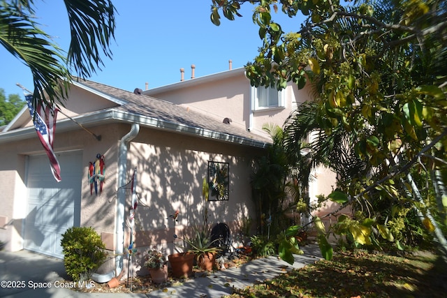 126 Plover Ln Unit 632, Rockledge, FL 32955 - view of side of property featuring stucco siding, a garage, and a shingled roof