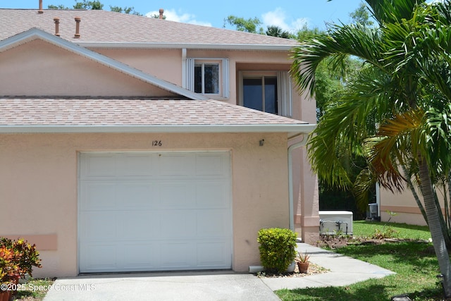 126 Plover Ln Unit 632, Rockledge, FL 32955 - view of front facade with a shingled roof, stucco siding, driveway, and an attached garage