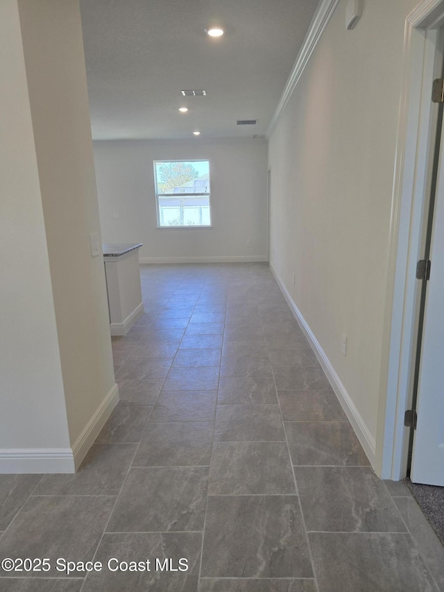 hall with tile patterned flooring, visible vents, crown molding, baseboards, and recessed lighting