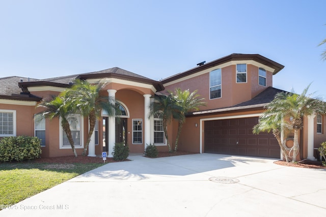 view of front of house featuring stucco siding, an attached garage, driveway, and a shingled roof