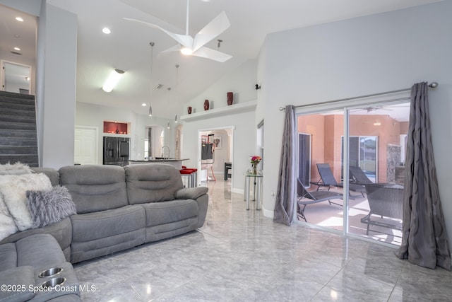 living room featuring stairs, high vaulted ceiling, marble finish floor, and a ceiling fan