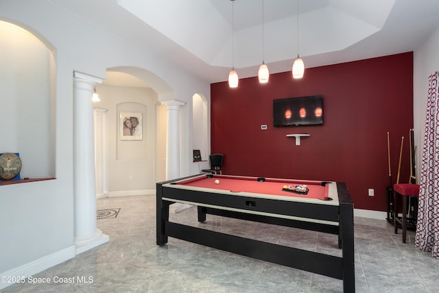 rec room with decorative columns, arched walkways, baseboards, and an accent wall