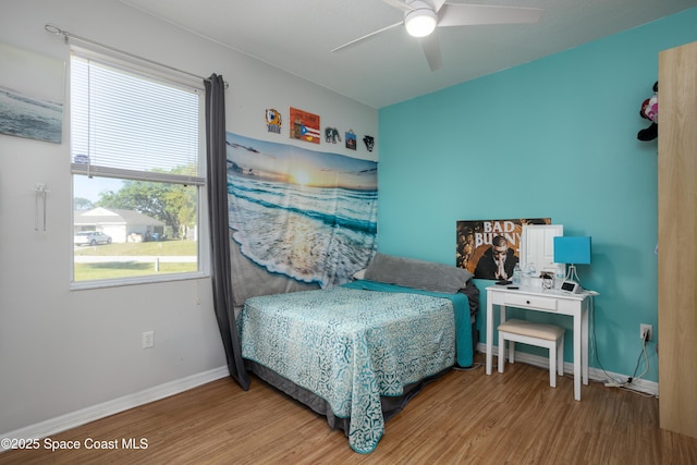 bedroom with baseboards, wood finished floors, and a ceiling fan