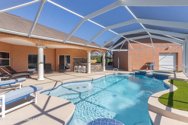 view of pool with outdoor dry bar, a pool with connected hot tub, a lanai, a patio area, and a ceiling fan