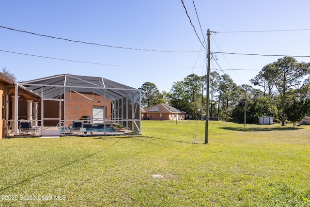 view of yard featuring glass enclosure, a swimming pool, and a patio area