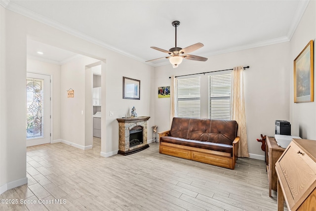 living room featuring washer / dryer, crown molding, light wood finished floors, and ceiling fan