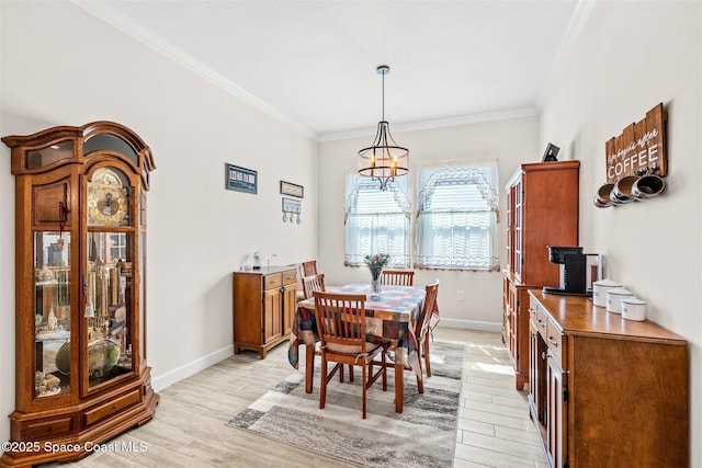 dining room with crown molding, a notable chandelier, light wood-style floors, and baseboards