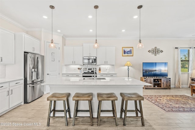 kitchen featuring light wood-type flooring, a kitchen bar, ornamental molding, decorative backsplash, and appliances with stainless steel finishes