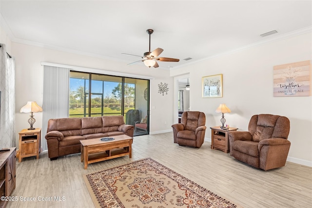 living room featuring crown molding, light wood-style flooring, a ceiling fan, and visible vents