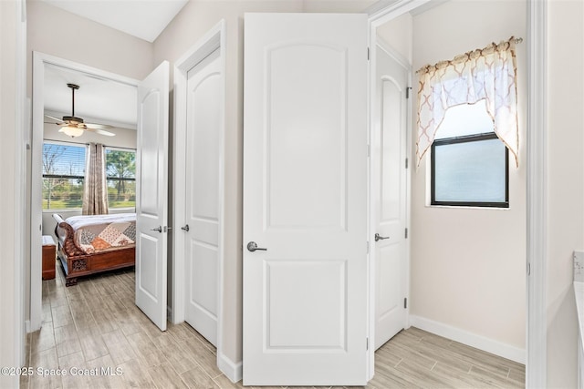 hallway featuring baseboards and wood tiled floor