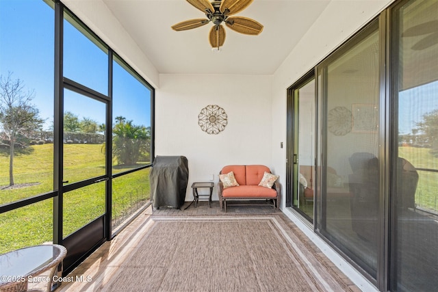 unfurnished sunroom featuring ceiling fan