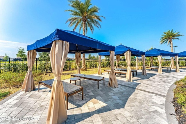 surrounding community with a gazebo, fence, and a patio area