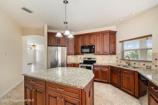 kitchen featuring visible vents, arched walkways, a sink, stainless steel appliances, and tasteful backsplash