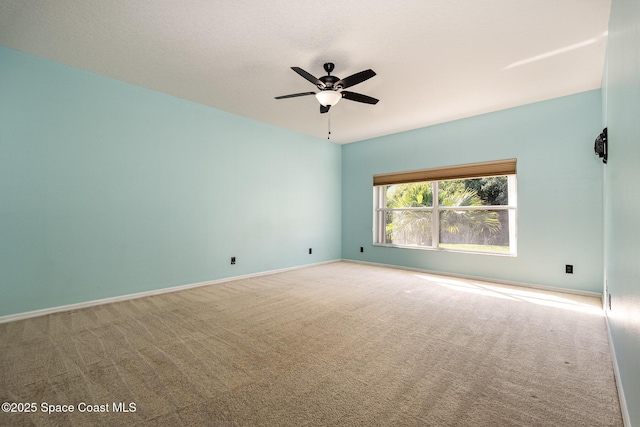 empty room featuring ceiling fan, baseboards, and carpet