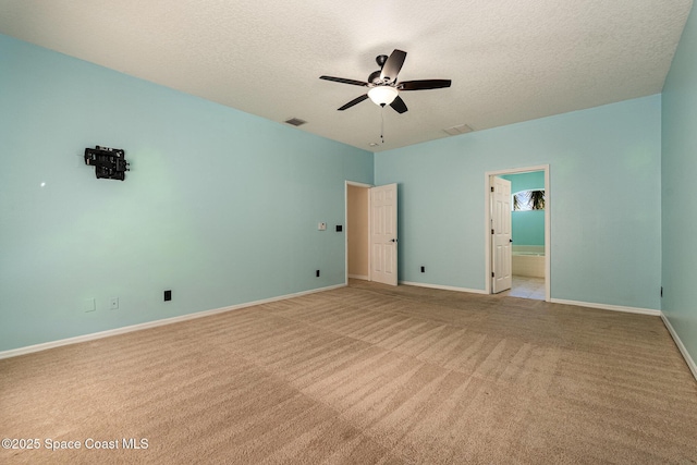 unfurnished bedroom featuring visible vents, a textured ceiling, baseboards, and carpet