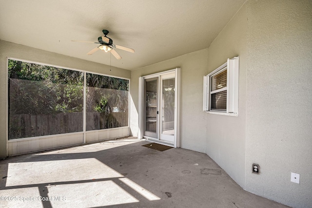 unfurnished sunroom with ceiling fan