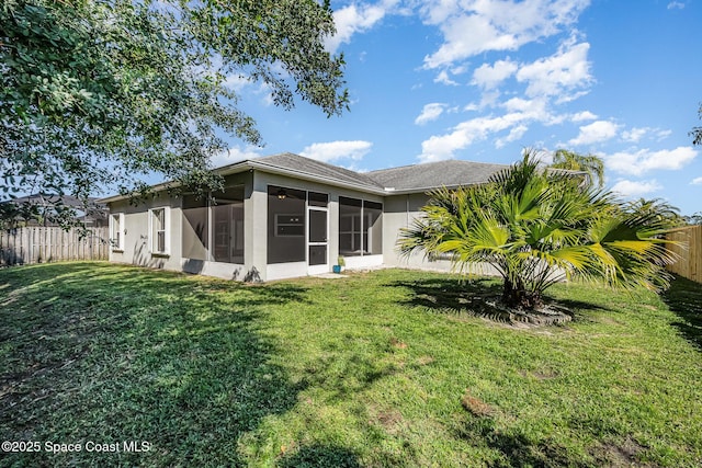 back of house featuring a yard, fence private yard, and a sunroom