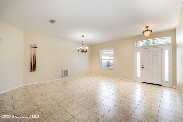 entryway featuring light tile patterned floors, visible vents, baseboards, and an inviting chandelier