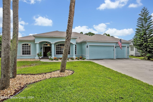 ranch-style home featuring stucco siding, concrete driveway, a front lawn, and a garage