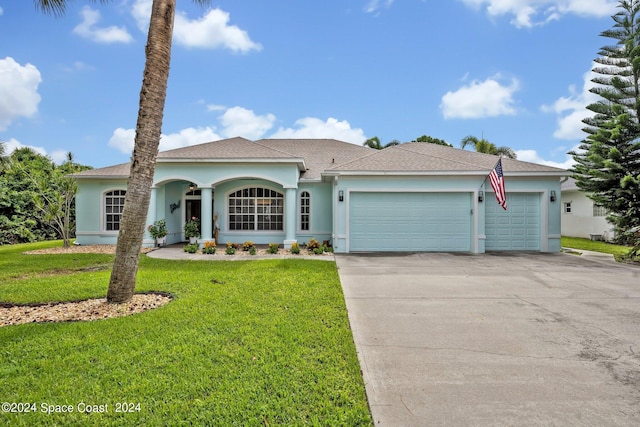 ranch-style house with stucco siding, a front lawn, concrete driveway, and an attached garage