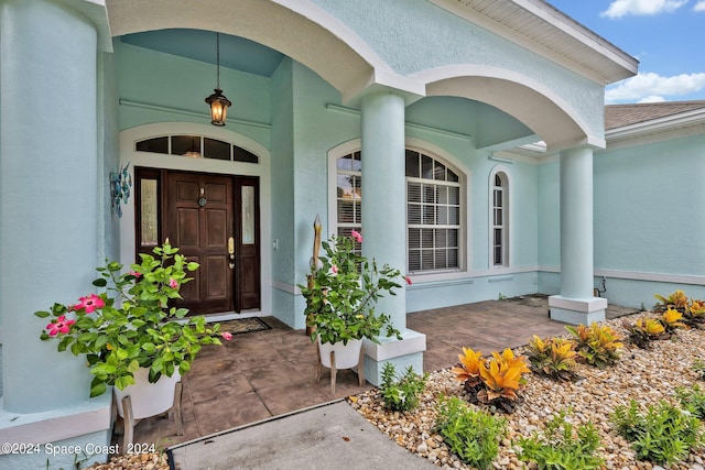 doorway to property featuring stucco siding