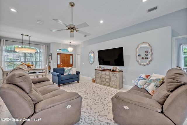 living room with light tile patterned flooring, recessed lighting, visible vents, and baseboards