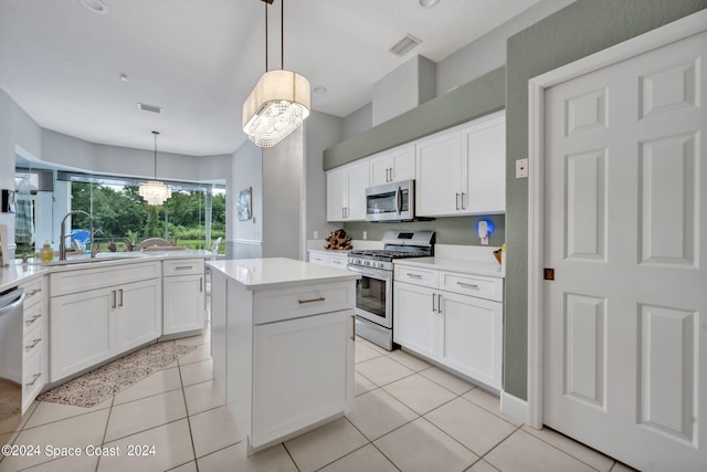 kitchen with visible vents, a sink, a center island, appliances with stainless steel finishes, and light tile patterned flooring